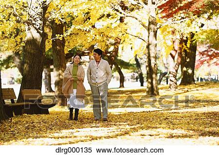 Stock Photography - Senior Japanese couple in a city park in Autumn. Fotosearch
