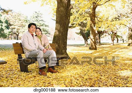 Senior Japanese couple sitting on a bench in a city park View Large Photo Image Stock Photo - Senior Japanese couple sitting on a bench in a city park. Fotosearch