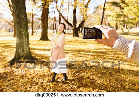 Senior Japanese couple taking pictures in a city park in Autumn View Large Photo Image Stock Image - Senior Japanese couple taking pictures in a city park in Autumn. Fotosearch