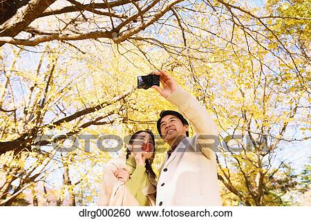 Senior Japanese couple taking pictures in a city park in Autumn View Large Photo Image Stock Image - Senior Japanese couple taking pictures in a city park in Autumn. Fotosearch