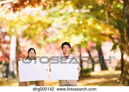 Senior Japanese couple with whiteboard in a city park View Large Photo Image Stock Image - Senior Japanese couple with whiteboard in a city park. Fotosearch