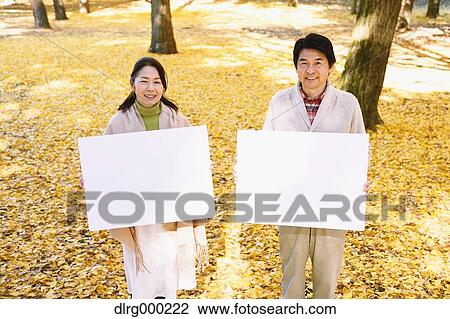 Senior Japanese couple with whiteboard in a city park View Large Photo Image Stock Image - Senior Japanese couple with whiteboard in a city park. Fotosearch