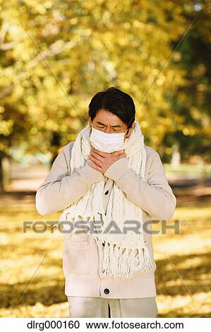 Stock Image - Senior Japanese man with mask feeling sick. Fotosearch