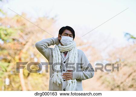 Stock Image - Senior Japanese man with mask feeling sick. Fotosearch
