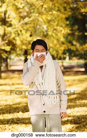 Stock Photo - Senior Japanese man with mask feeling sick. Fotosearch