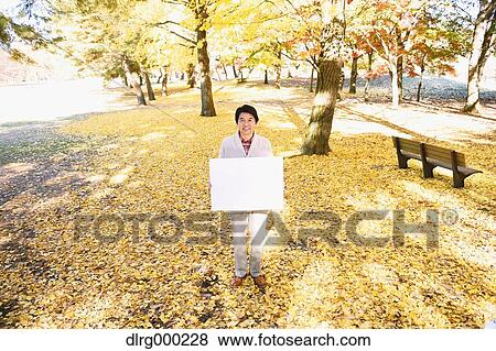 Senior Japanese man with whiteboard in a city park in Autumn View Large Photo Image Stock Photo - Senior Japanese man with whiteboard in a city park in Autumn. Fotosearch