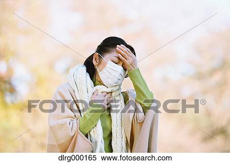 Stock Photography - Senior Japanese woman with mask feeling sick. Fotosearch