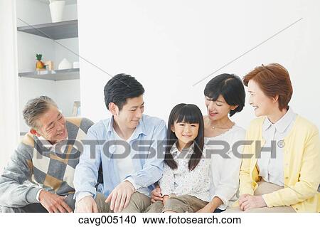 Stock Image - Three-generation Japanese family on the sofa in the living room. Fotosearch
