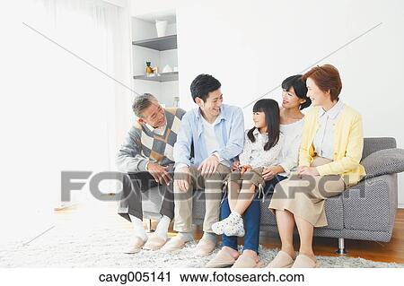 Stock Image - Three-generation Japanese family on the sofa in the living room. Fotosearch
