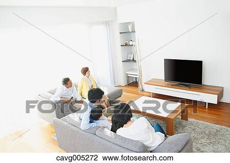 Stock Image - Three-generation Japanese family on the sofa in the living room. Fotosearch