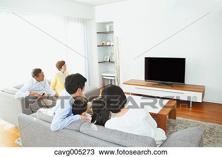 Stock Image - Three-generation Japanese family on the sofa in the living room. Fotosearch