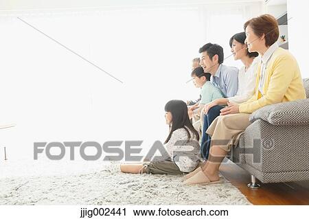 Stock Image - Three-generation Japanese family on the sofa in the living room. Fotosearch