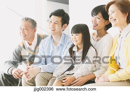 Stock Photograph - Three-generation Japanese family on the sofa in the living room. Fotosearch