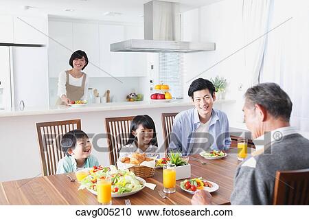 Stock Image - Three-generation Japanese family together in the kitchen. Fotosearch