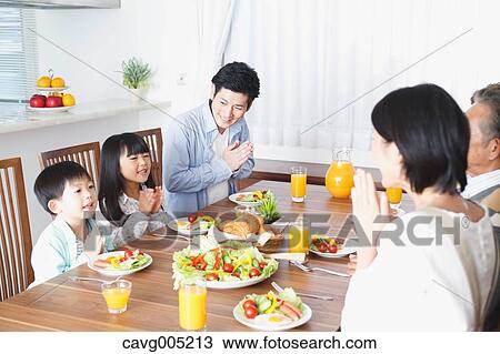 Stock Image - Three-generation Japanese family together in the kitchen. Fotosearch