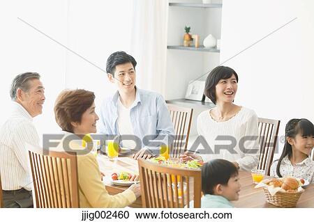 Stock Image - Three-generation Japanese family together in the kitchen. Fotosearch
