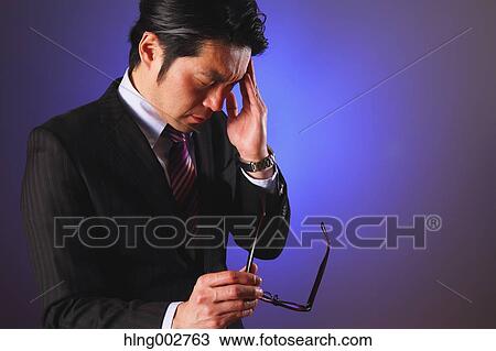 Stock Image - Tired Japanese businessman. Fotosearch