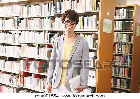 Picture - University student in the library. Fotosearch