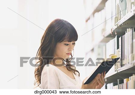 Stock Image - University student in the library. Fotosearch