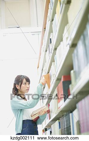 Stock Image - University student in the library. Fotosearch
