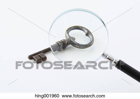 Stock Image - Vintage key and magnifying glass. Fotosearch