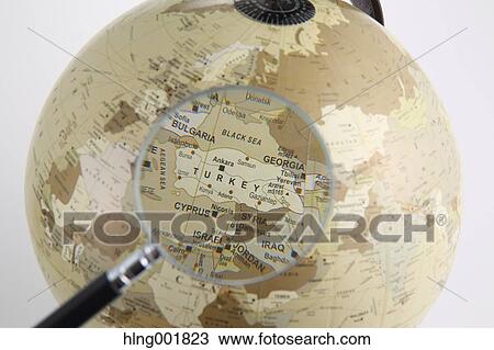 Stock Image - World globe and magnifying glass. Fotosearch