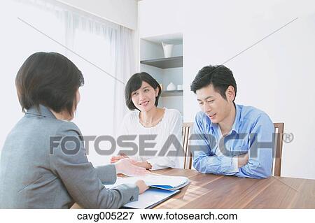 Stock Photo - Young Japanese couple consulting with financial planner. Fotosearch