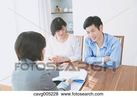 Stock Photo - Young Japanese couple consulting with financial planner. Fotosearch