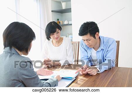 Stock Photograph - Young Japanese couple consulting with financial planner. Fotosearch