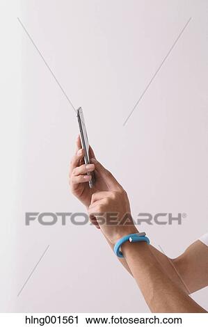 Stock Image - Young Japanese man using smartphone. Fotosearch
