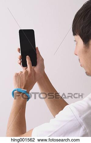 Young Japanese man using smartphone View Large Photo Image Stock Image - Young Japanese man using smartphone. Fotosearch