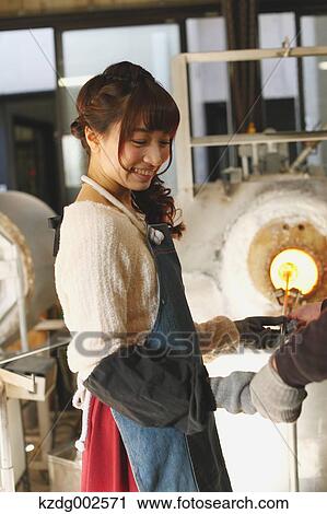 Stock Image - Young Japanese woman enjoying glass crafting workshop in Kawagoe, Japan. Fotosearch