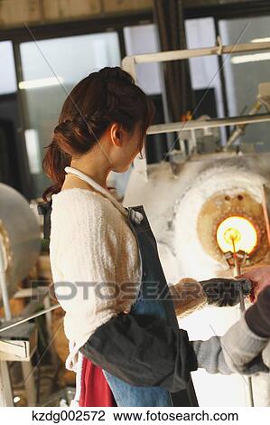Stock Image - Young Japanese woman enjoying glass crafting workshop in Kawagoe, Japan. Fotosearch