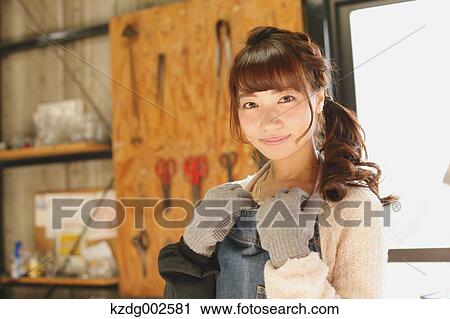 Stock Image - Young Japanese woman enjoying glass crafting workshop in Kawagoe, Japan. Fotosearch