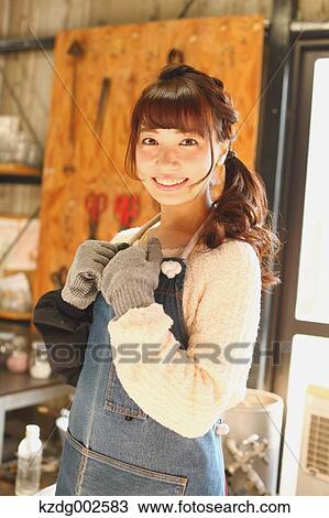 Stock Image - Young Japanese woman enjoying glass crafting workshop in Kawagoe, Japan. Fotosearch