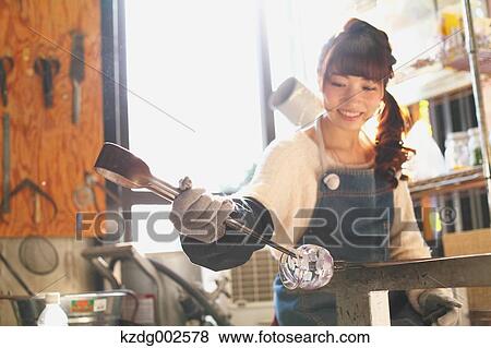 Stock Photo - Young Japanese woman enjoying glass crafting workshop in Kawagoe, Japan. Fotosearch