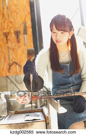 Stock Photography - Young Japanese woman enjoying glass crafting workshop in Kawagoe, Japan. Fotosearch