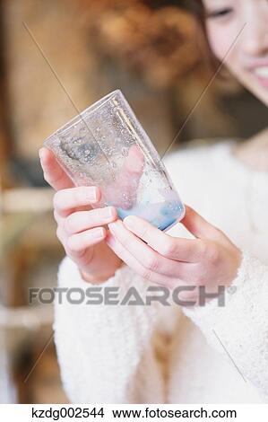 Picture - Young Japanese woman enjoying visit to glass workshop in Kawagoe, Japan. Fotosearch
