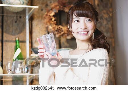 Stock Photography - Young Japanese woman enjoying visit to glass workshop in Kawagoe, Japan. Fotosearch