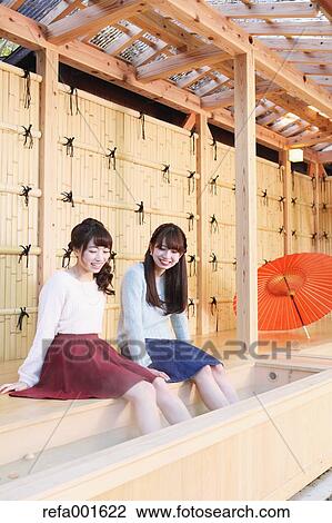 Stock Image - Young Japanese women enjoying foot spa in Kawagoe, Japan. Fotosearch