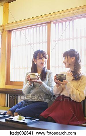 Stock Image - Young Japanese women enjoying Maccha green tea in Kawagoe, Japan. Fotosearch
