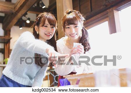 Picture - Young Japanese women enjoying visit to glass workshop in Kawagoe, Japan. Fotosearch