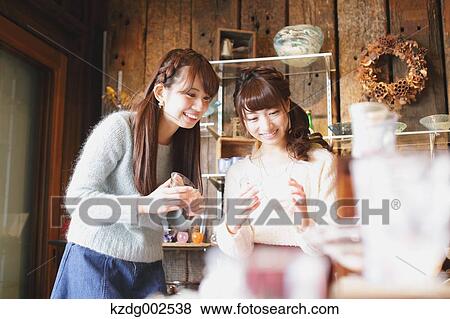 Stock Photo - Young Japanese women enjoying visit to glass workshop in Kawagoe, Japan. Fotosearch