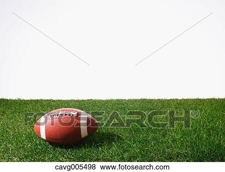 Stock Photo - American football ball on grass. Fotosearch
