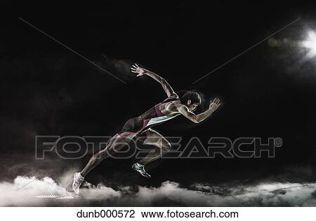 Stock Image - Athlete running in the smoke. Fotosearch