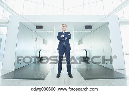 Stock Image - Caucasian businessman on escalator. Fotosearch