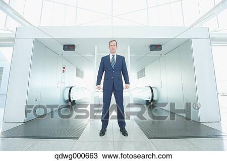 Stock Image - Caucasian businessman on escalator. Fotosearch