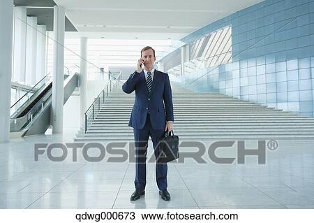 Stock Image - Caucasian businessman on the phone in modern office. Fotosearch