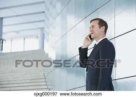 Stock Photo - Caucasian businessman on the phone in modern office. Fotosearch