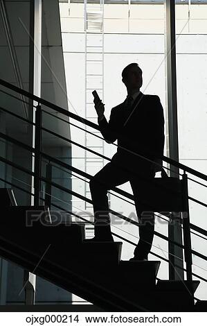 Caucasian businessman with phone in modern office View Large Photo Image Picture - Caucasian businessman with phone in modern office. Fotosearch